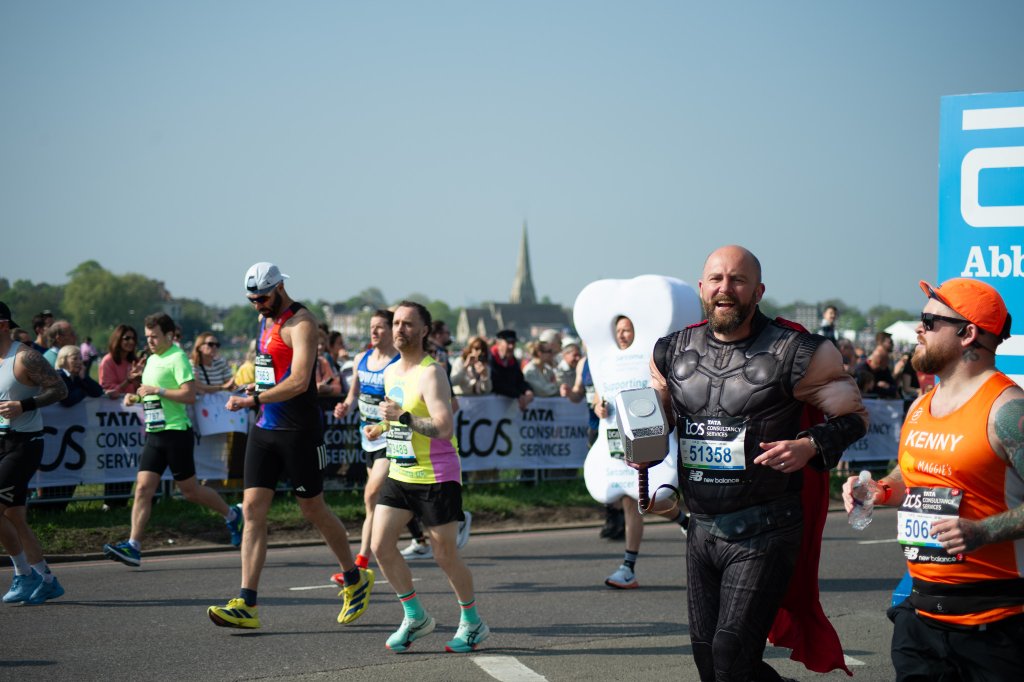 Children in fairy costumes giving high-fives to runners