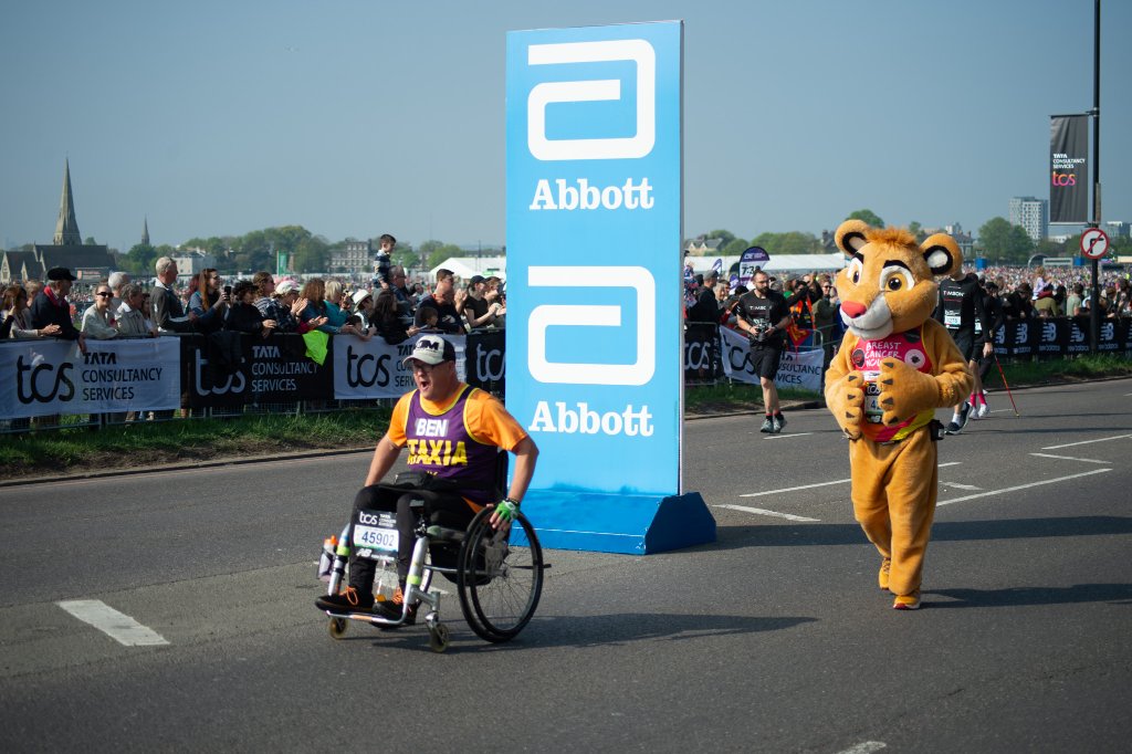 Child high-fiving a runner at the barrier