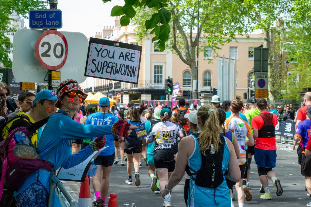 Spectator with Union Flag watching runners