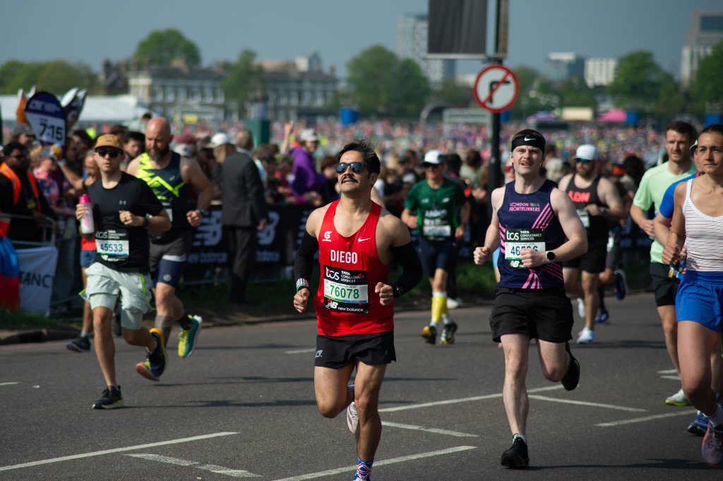 Ben runner smiling in orange-trimmed black vest