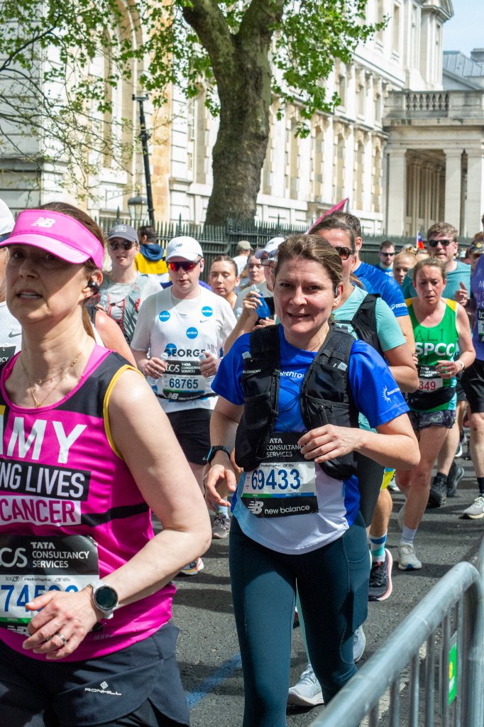 Large group of runners on a road lined with terraced houses